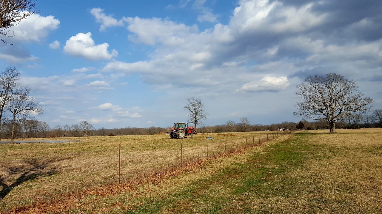 TRACTOR ON FIELD AGAINST SKY