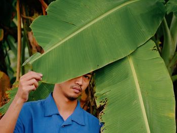 Portrait of young man with leaves