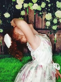 Midsection of woman holding plant in field