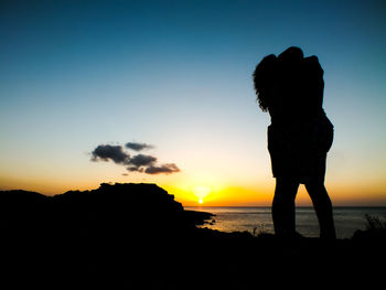 Silhouette couple on beach at sunset