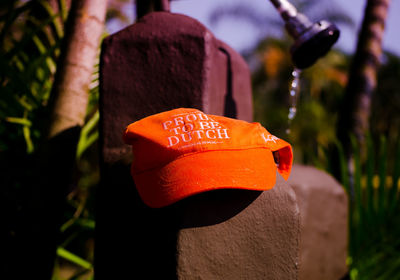 Close-up of orange baseball cap on stone