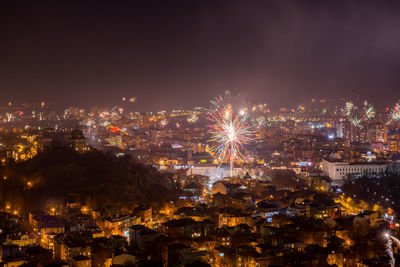 Illuminated cityscape against sky at night