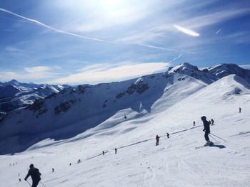 People on snowcapped mountain against sky