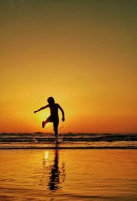 People walking on beach at sunset