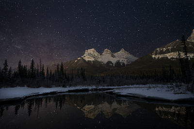 Scenic view of snowcapped mountains against sky at night