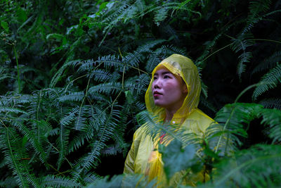 Portrait of young woman looking at plants