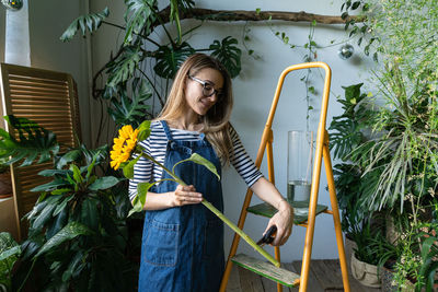 Full length of woman standing against plants