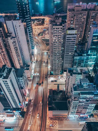 High angle view of illuminated street amidst buildings in city at night