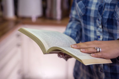 Midsection of woman reading book