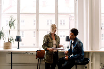 Business coworkers discussing document while working in office