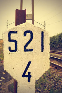 Close-up of information sign on railroad track