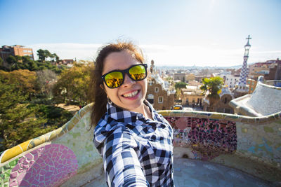 Portrait of smiling man wearing sunglasses against sky