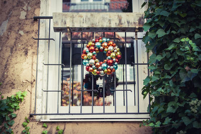 Multi colored wreath of christmas baubles on window 