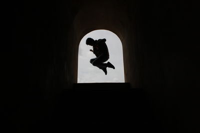 Low angle view of silhouette man against black background