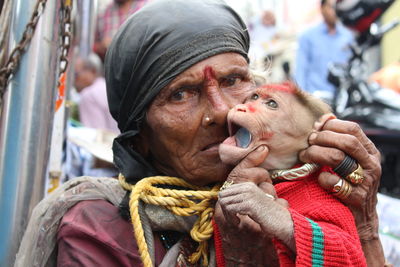 Close-up of senior woman with monkey outdoors