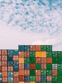 Stack of conttainers at commercial dock against sky