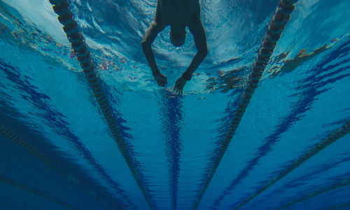 Low section of person standing in swimming pool