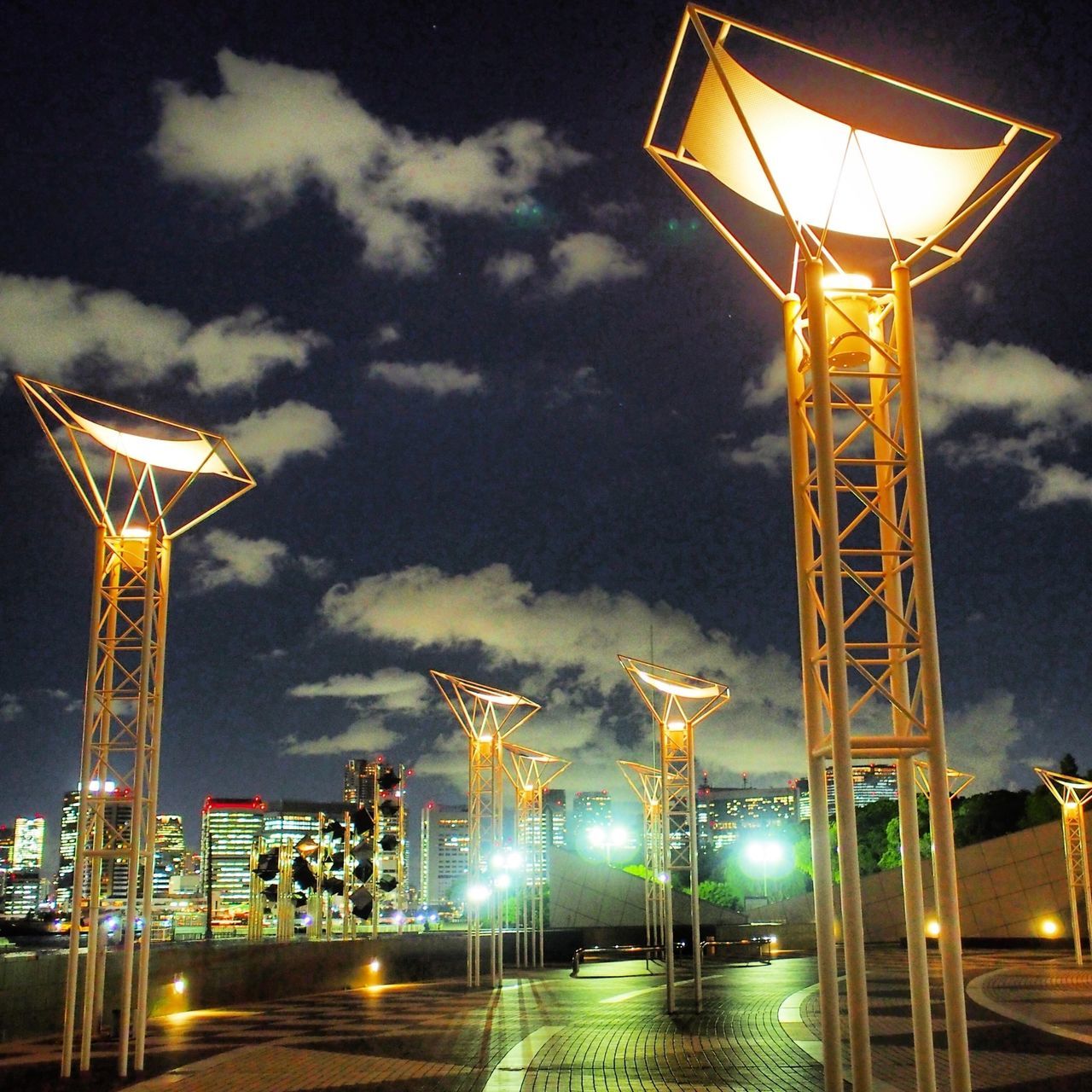 illuminated, sky, night, built structure, architecture, cloud - sky, low angle view, building exterior, dusk, cloudy, crane - construction machinery, lighting equipment, outdoors, tall - high, communication, communications tower, cloud, tower, industry, travel destinations