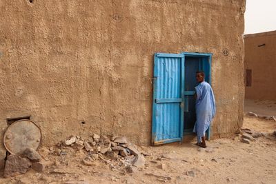 Full length of man standing against building