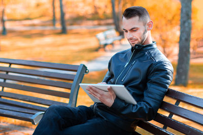Man looking away while sitting on bench