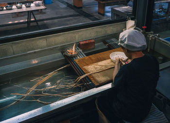 Rear view of man working on water