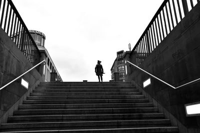 Low angle view of man standing on staircase against sky