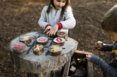 Children playing tic tac toe at natural outdoor playground in texas