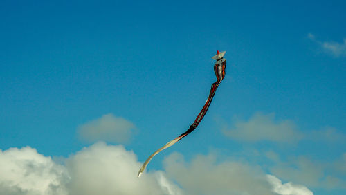 Low angle view of airplane flying against blue sky