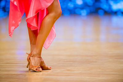 Low section of woman wearing high heels dancing on floor