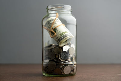 Close-up of coins in jar on table
