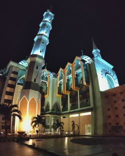 Low angle view of illuminated buildings against sky at night