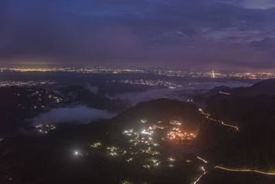 Aerial view of illuminated city against sky at night