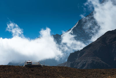 Panoramic view of land and mountains against blue sky