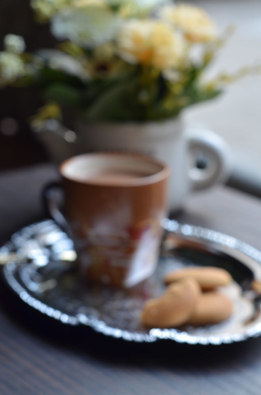 CLOSE-UP OF COFFEE CUP AND SAUCER ON TABLE