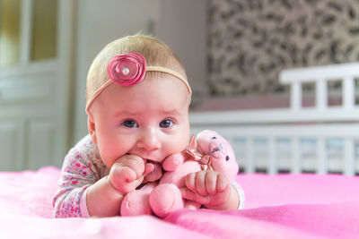 Portrait of cute baby boy lying on bed at home