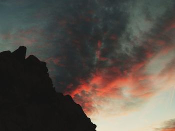Low angle view of silhouette mountain against dramatic sky