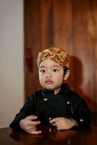 Little boy wearing javanese traditional uniform and blangkon