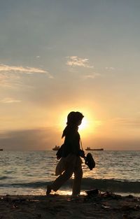 Full length of woman on beach during sunset