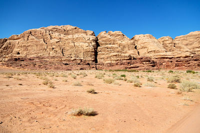 Rock formations in desert against clear blue sky