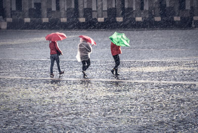 People walking on wet road during rainy season