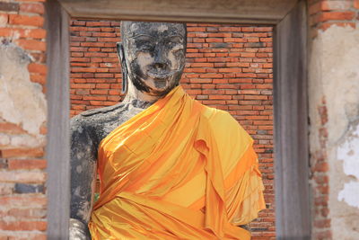 Statue against brick wall of building