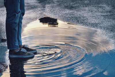 Low section of man standing in water