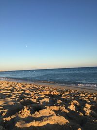 Scenic view of beach against clear blue sky