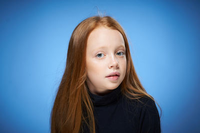 Portrait of cute girl against blue background