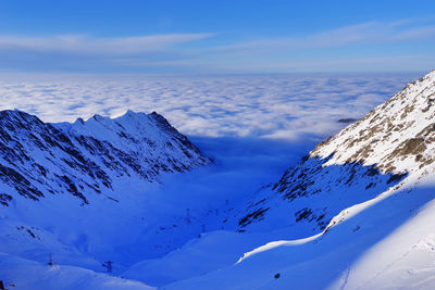 Scenic view of snowcapped mountains against blue sky