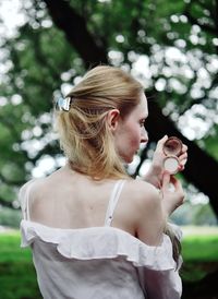 Midsection of woman standing by tree against plants