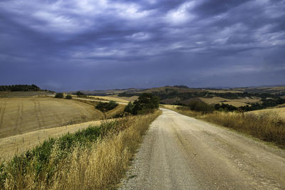 Road amidst field against sky