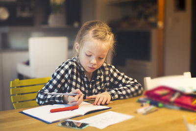 Boy sitting on table at home