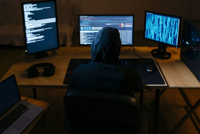 Computer hacker doing coding on computer while sitting at office