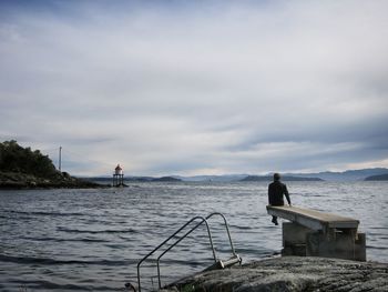 Man standing on sea against sky